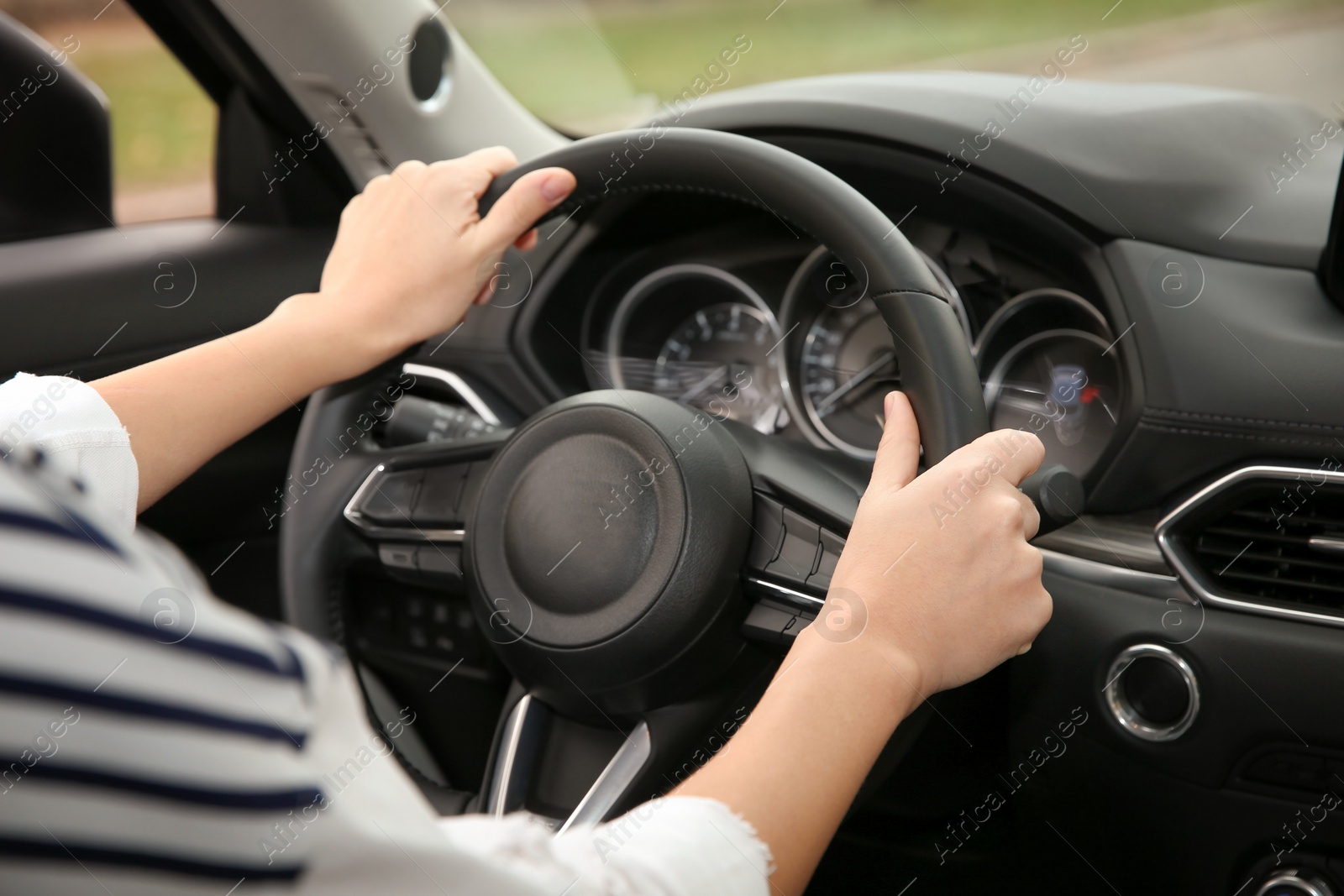 Photo of Woman holding steering wheel in car, closeup. Driving license test