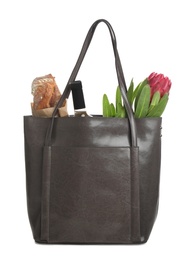 New leather shopper bag with purchases on white background