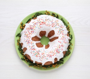 Photo of Glazed Easter cake with sprinkles on white wooden table, top view