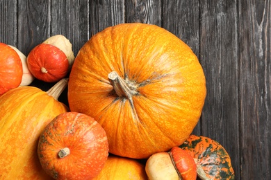 Photo of Flat lay composition with different pumpkins on wooden background. Autumn holidays