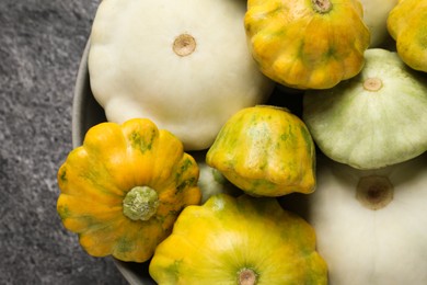 Photo of Fresh ripe pattypan squashes in bowl on grey table, top view