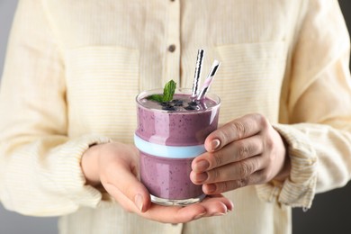 Woman with glass of tasty blueberry smoothie, closeup