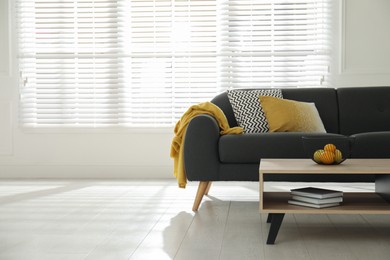 Stylish living room interior with comfortable grey sofa and table