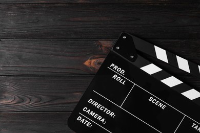 Photo of Clapperboard on wooden table, top view. Space for text