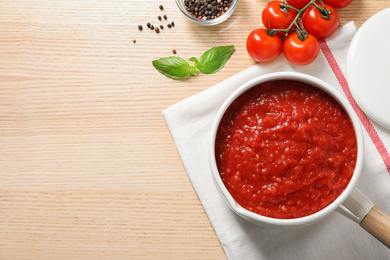 Photo of Flat lay composition with delicious tomato sauce on wooden table, space for text