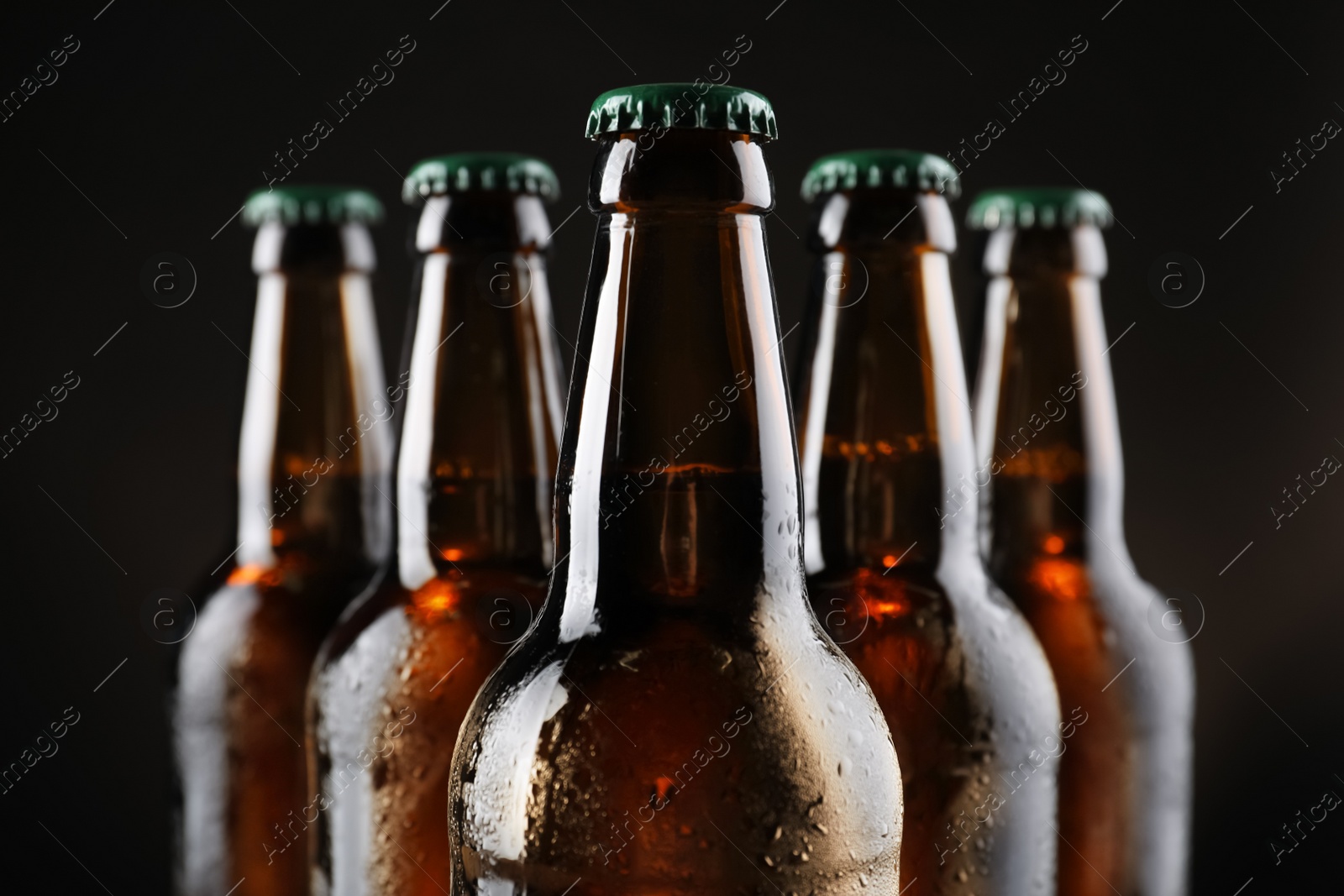 Photo of Many bottles of beer on dark background, closeup