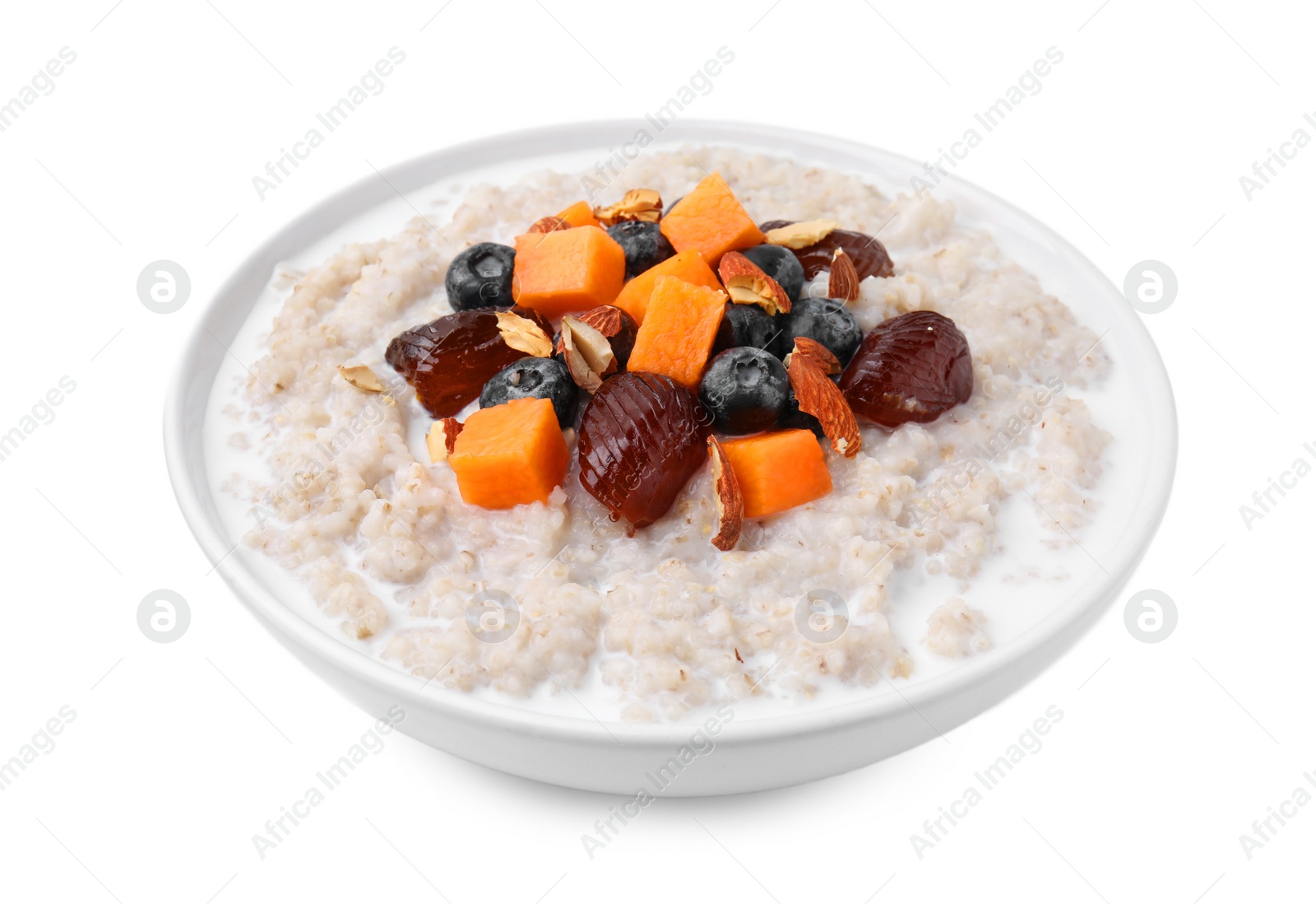 Photo of Delicious barley porridge with blueberries, pumpkin, dates and almonds in bowl isolated on white