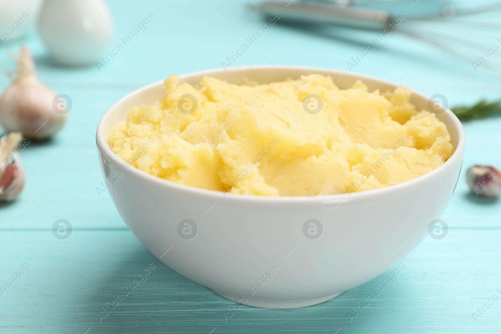 Photo of Bowl with mashed potatoes on wooden table