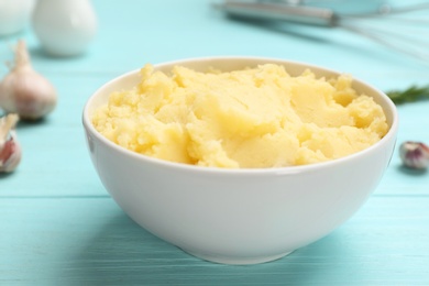 Photo of Bowl with mashed potatoes on wooden table