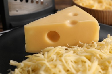 Grated and whole piece of cheese on plate, closeup