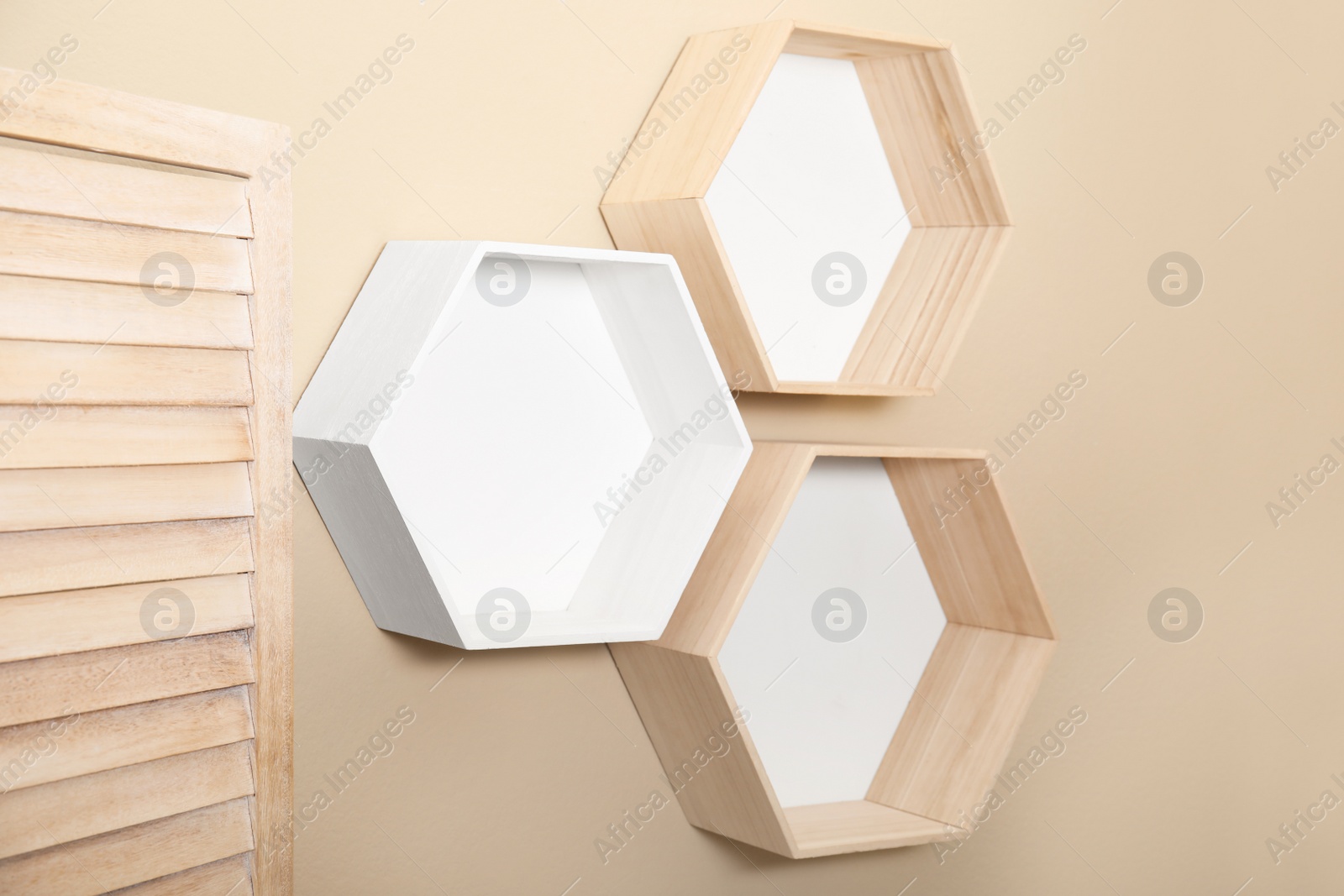 Photo of Empty honeycomb shaped shelves on beige wall