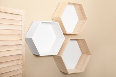 Photo of Empty honeycomb shaped shelves on beige wall