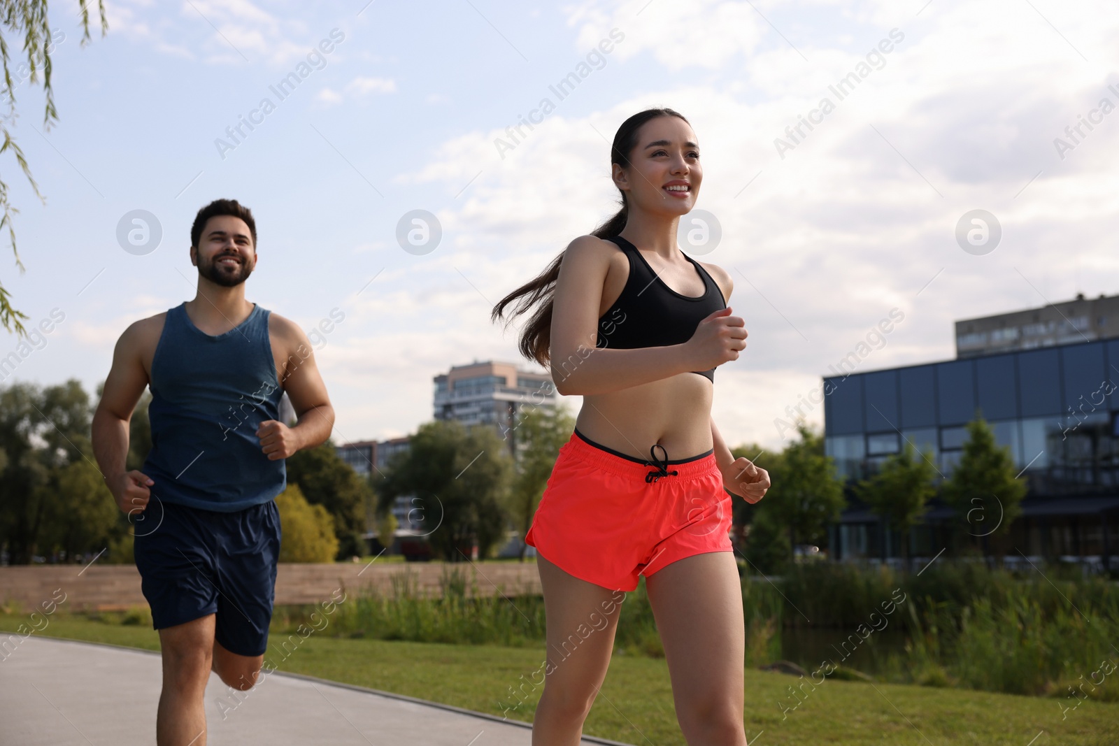 Photo of Healthy lifestyle. Happy couple running outdoors on sunny day