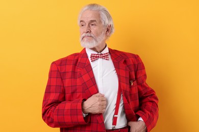 Photo of Portrait of grandpa with stylish red suit and bowtie on yellow background