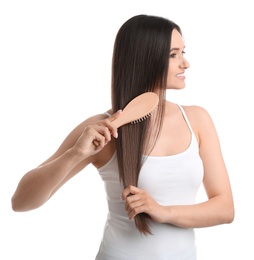 Beautiful young woman with hair brush on white background