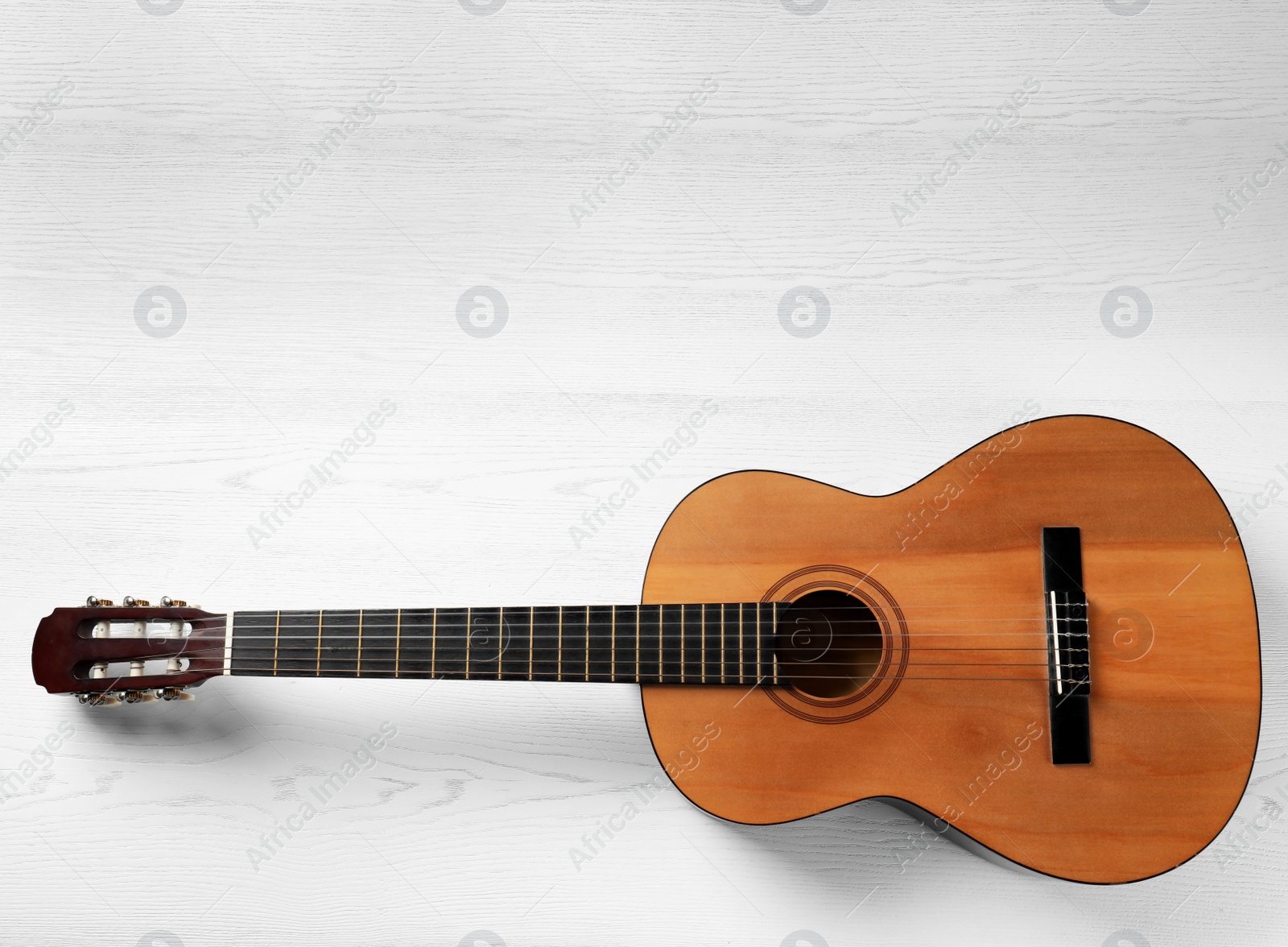 Photo of Beautiful classical guitar on wooden background, top view