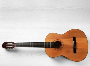 Beautiful classical guitar on wooden background, top view