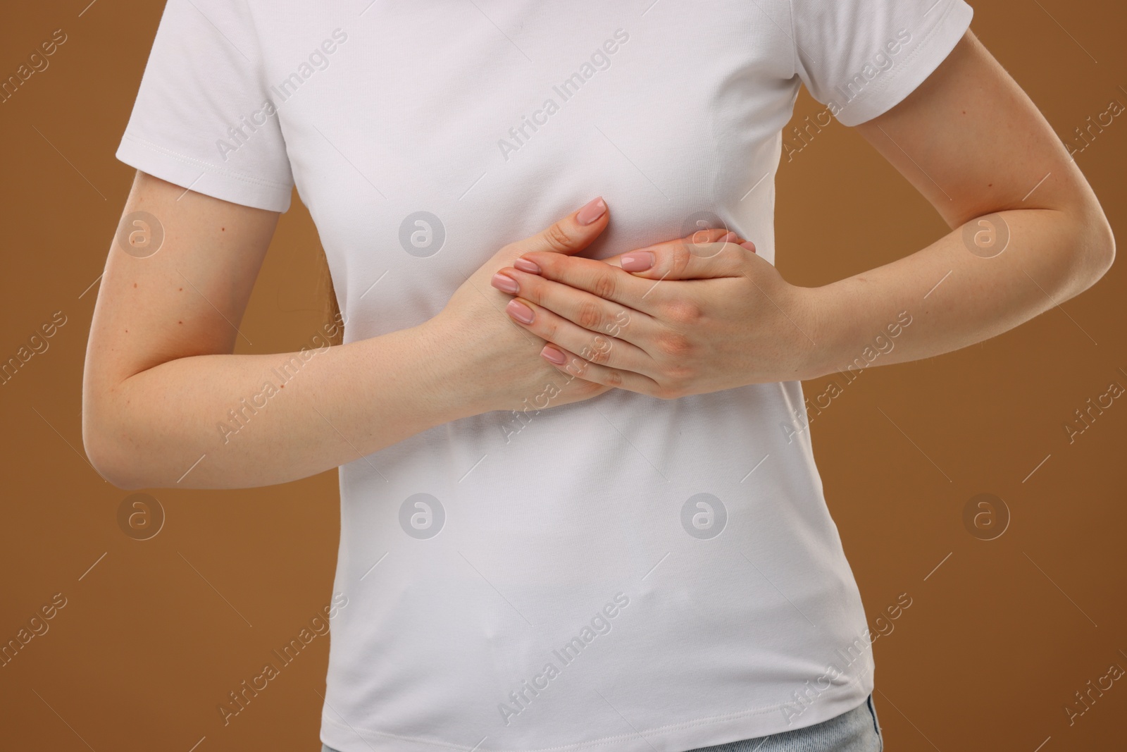 Photo of Woman having heart attack on brown background, closeup