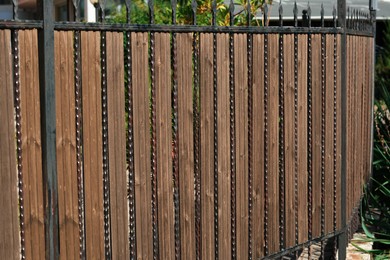 Metal and wooden fence outdoors on sunny day