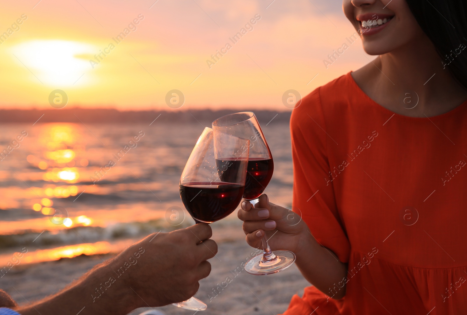 Photo of Lovely couple having picnic near river at sunset, closeup