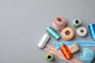 Photo of Color sewing threads on gray background, top view