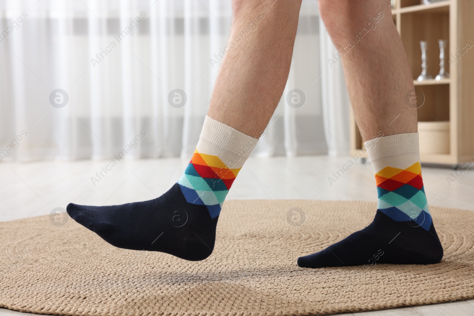 Photo of Man in stylish colorful socks indoors, closeup