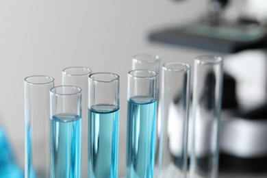 Photo of Test tubes with light blue liquid in laboratory, closeup