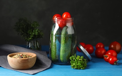 Photo of Pickling jar with fresh ripe vegetables and spices on blue wooden table