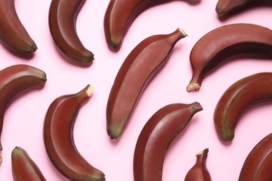 Tasty red baby bananas on pink background, flat lay