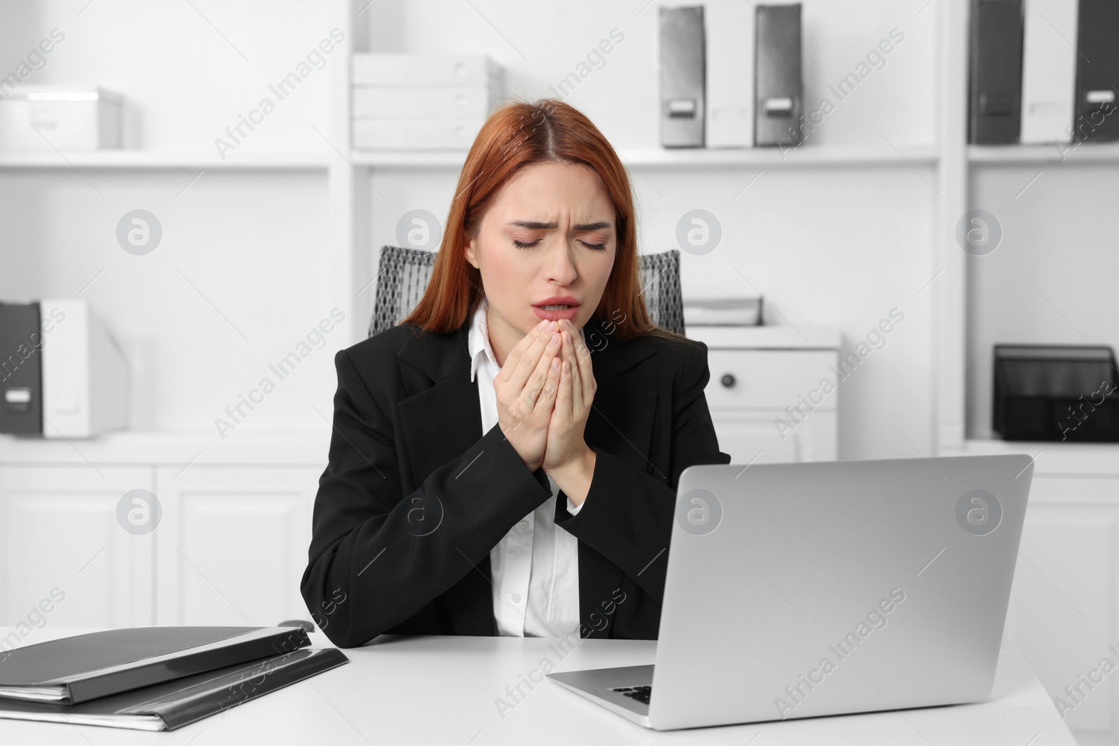 Photo of Woman coughing at table in office. Cold symptoms