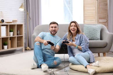 Photo of Young couple playing video game at home