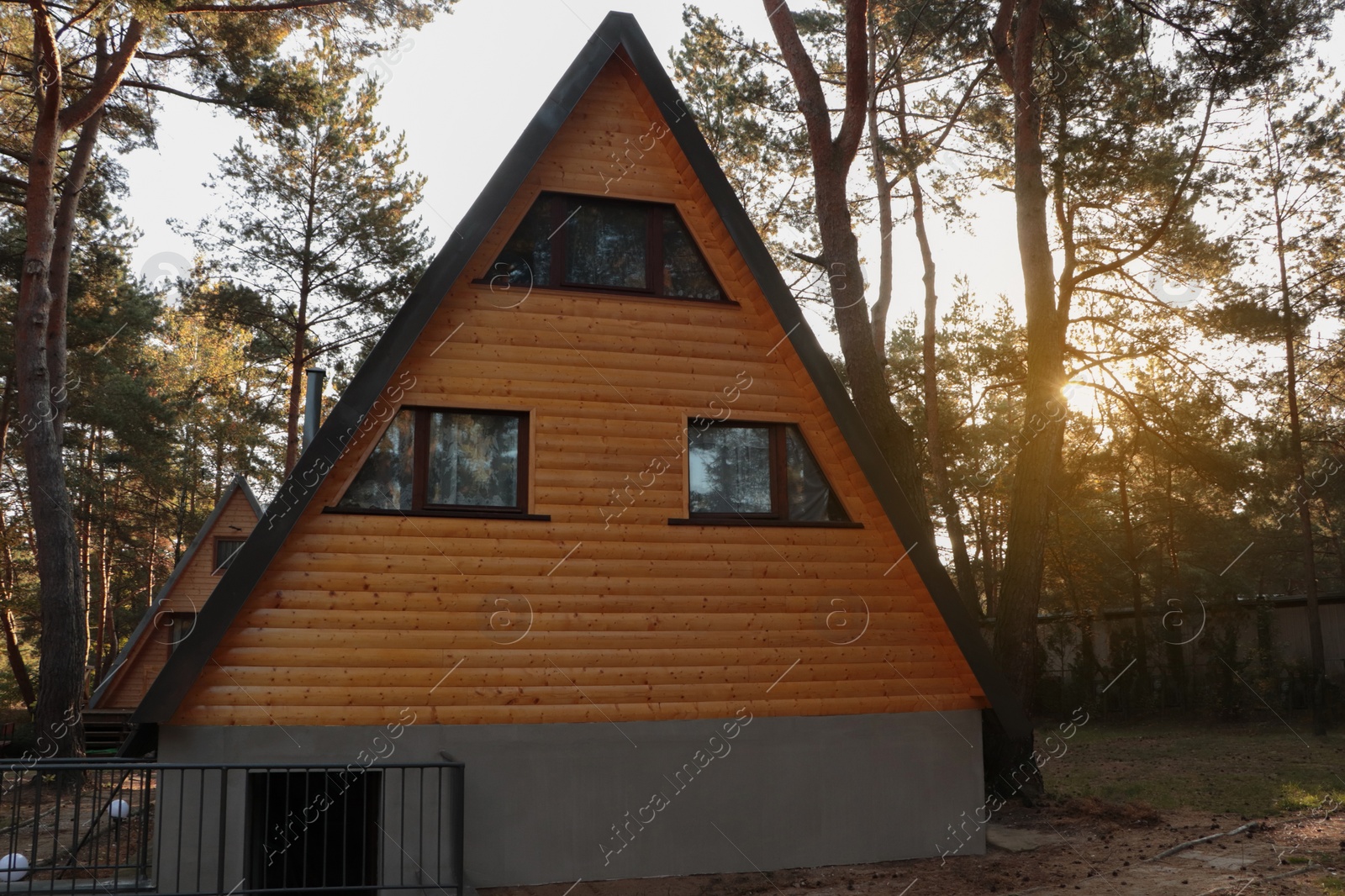 Photo of Picturesque view of modern wooden house near forest on sunny day
