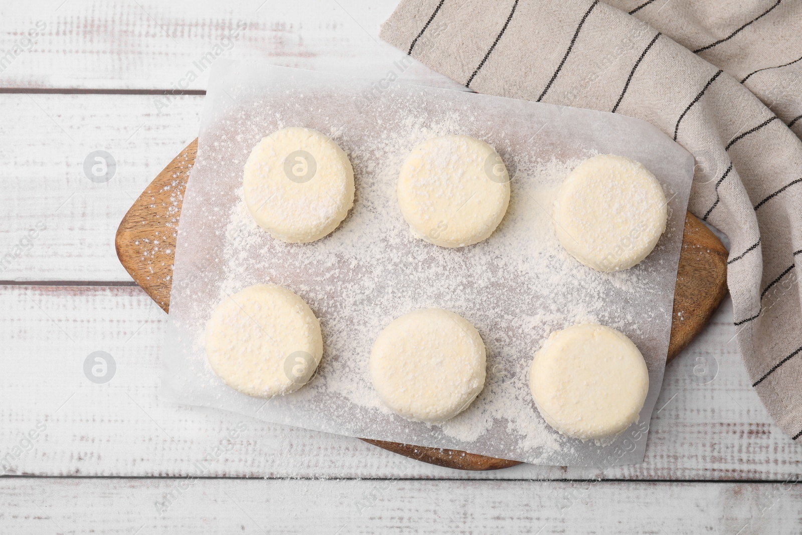 Photo of Uncooked cottage cheese pancakes on white wooden table, top view