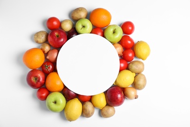 Flat lay composition with fresh vegetables, fruits and blank card on white background, space for text