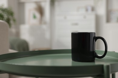 Photo of Blank ceramic mug on green table. Mockup for design