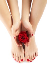Photo of Woman with stylish red toenails after pedicure procedure and rose flower isolated on white, top view