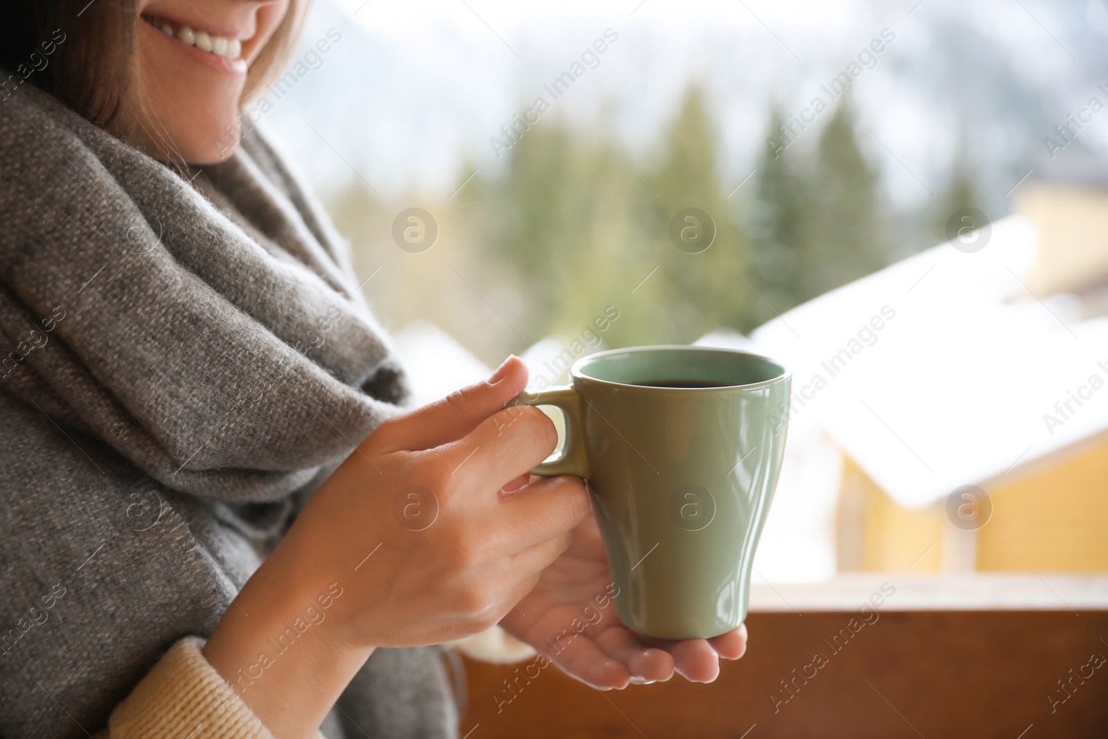 Photo of Woman with cup of tasty coffee outdoors on winter morning, closeup