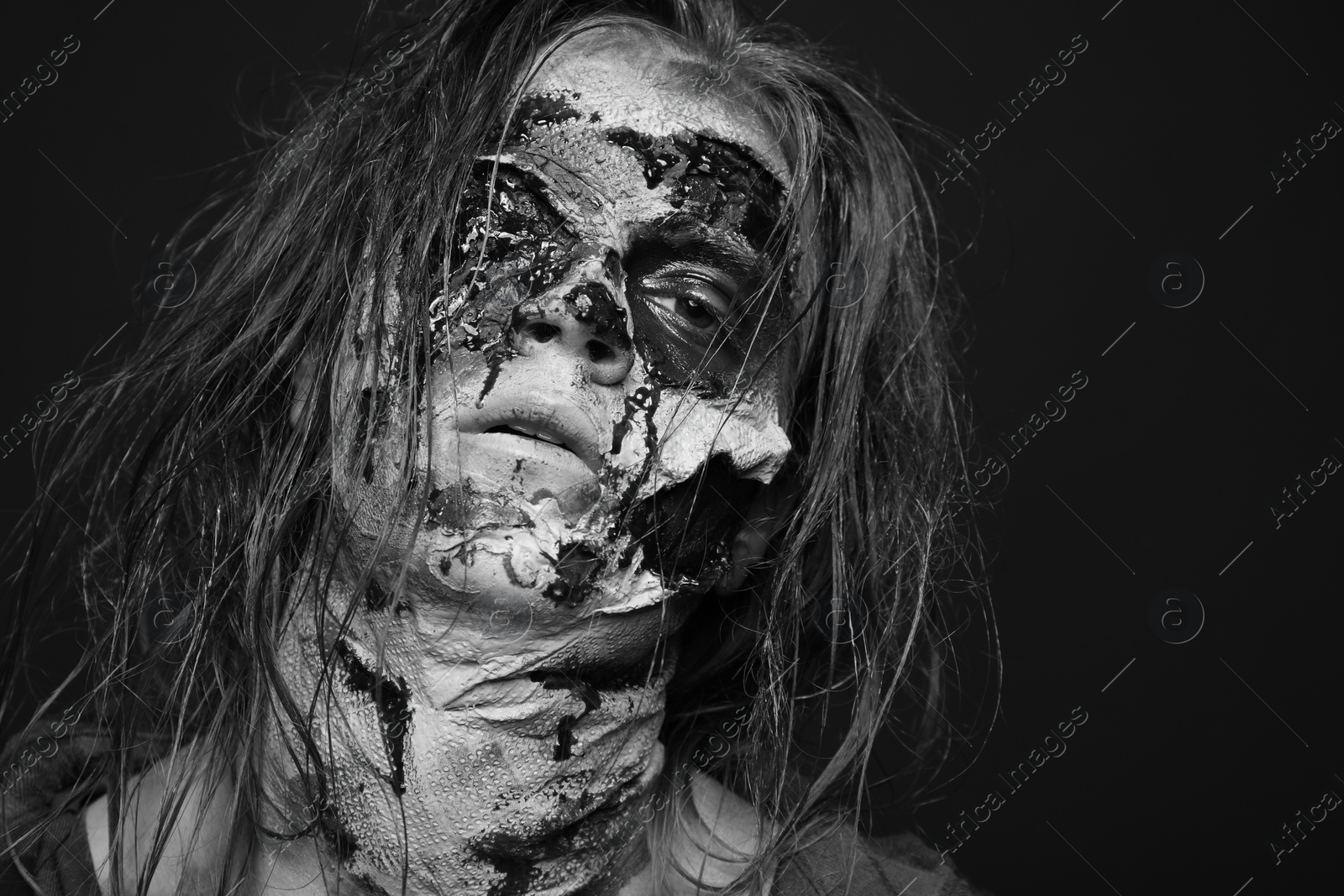 Photo of Scary zombie on dark background, black and white effect. Halloween monster