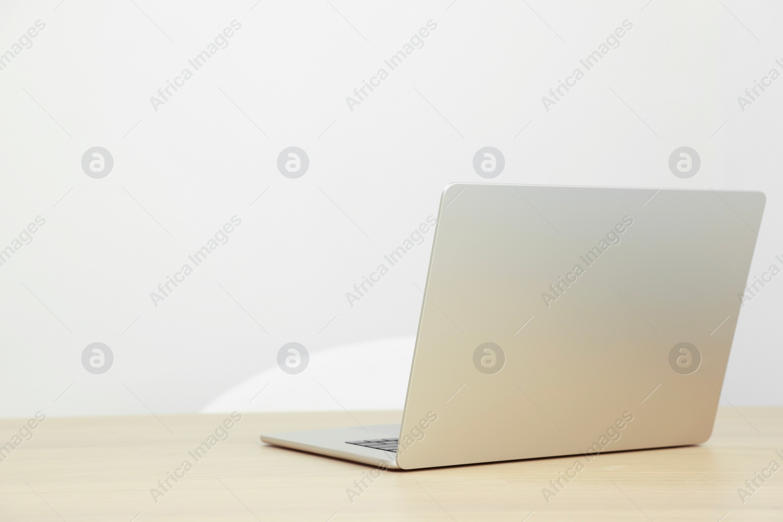 Photo of Modern laptop on wooden table. Space for text