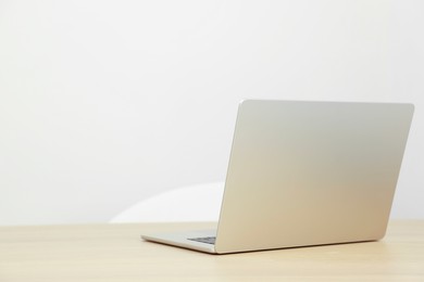 Photo of Modern laptop on wooden table. Space for text