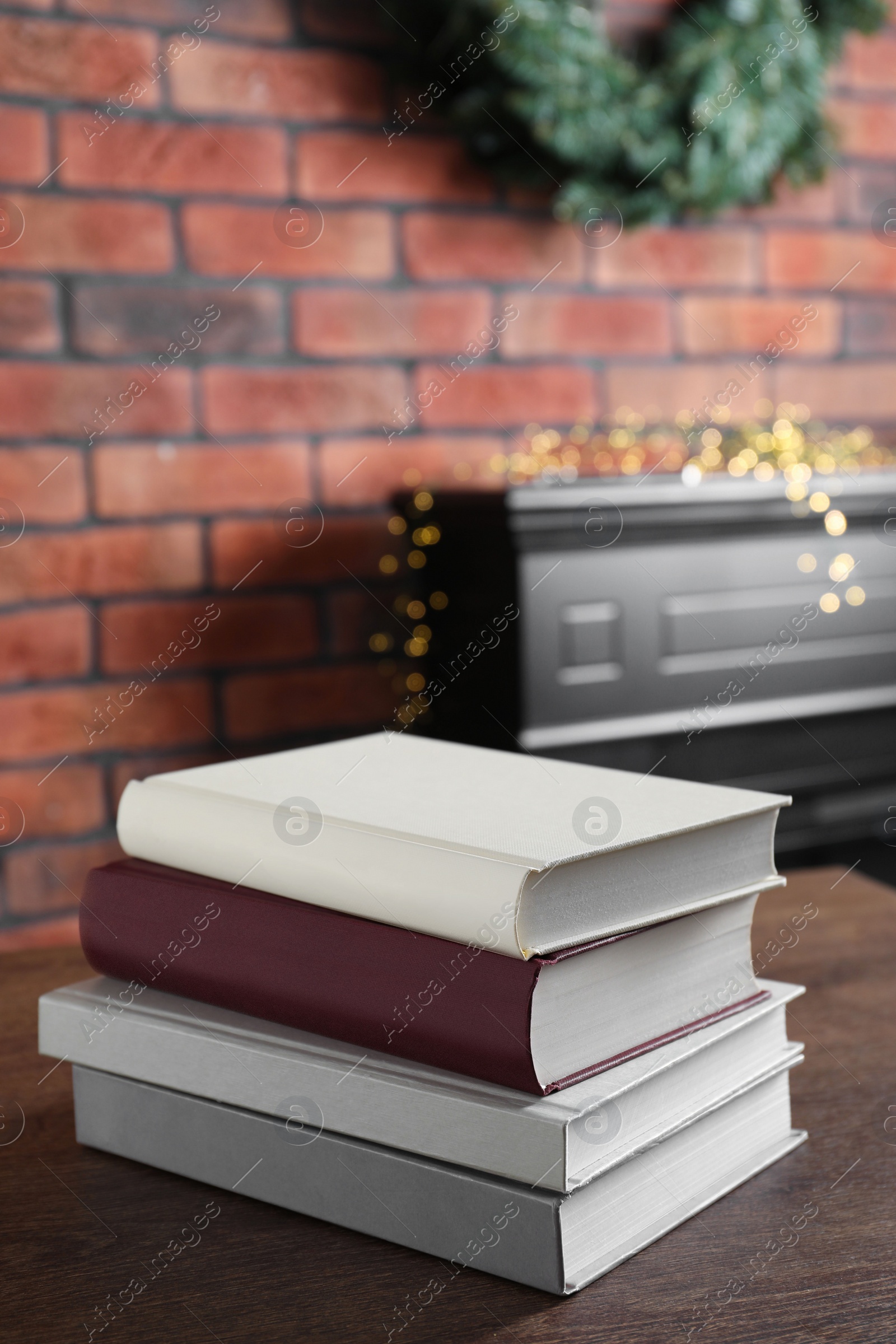 Photo of Stack of hardcover books on wooden table indoors