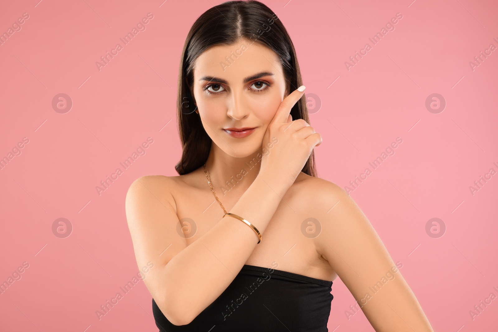 Photo of Beautiful woman with elegant jewelry on pink background