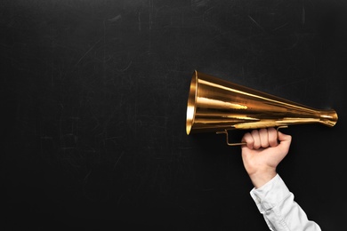 Photo of Man holding retro megaphone near chalkboard