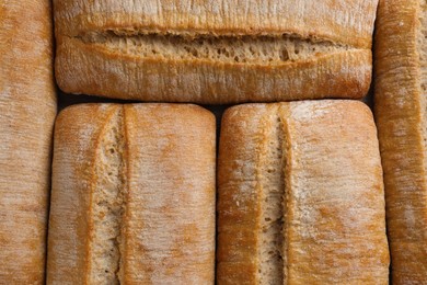 Photo of Crispy ciabattas as background, top view. Fresh bread