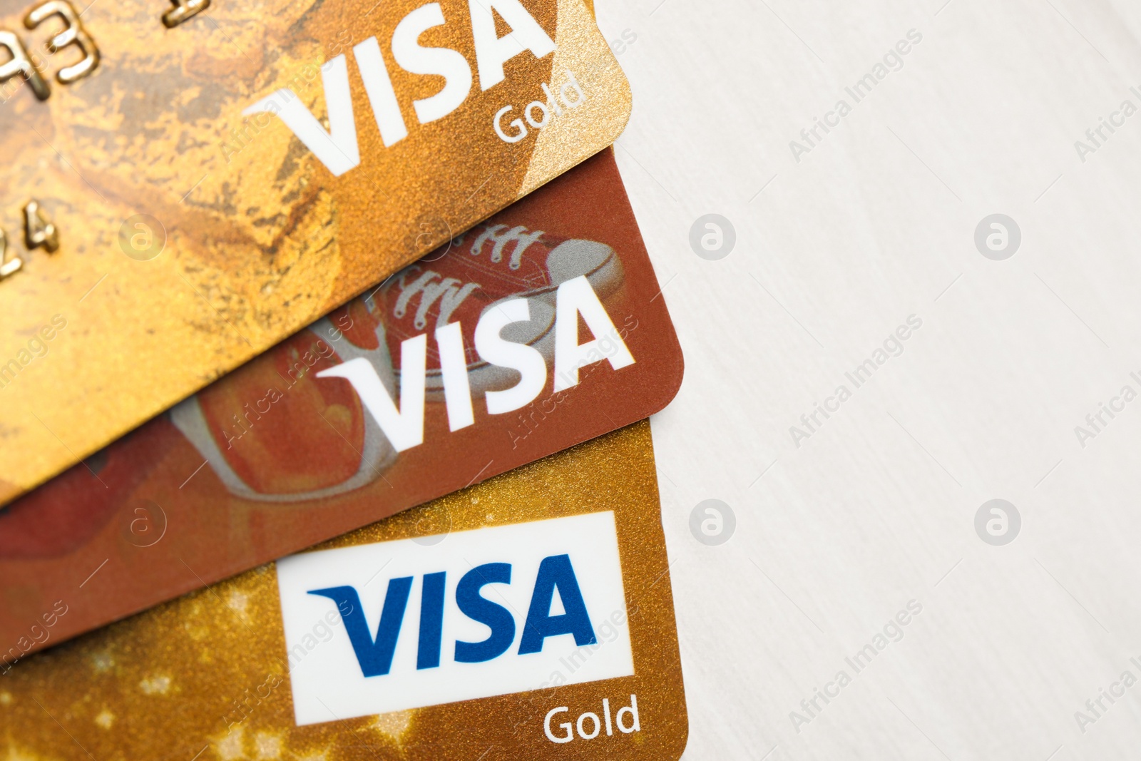 Photo of MYKOLAIV, UKRAINE - FEBRUARY 23, 2022: Bank cards of Visa payment system on wooden table, top view. Space for text