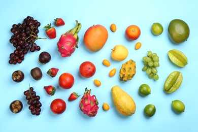 Many different delicious exotic fruits on light blue background, flat lay