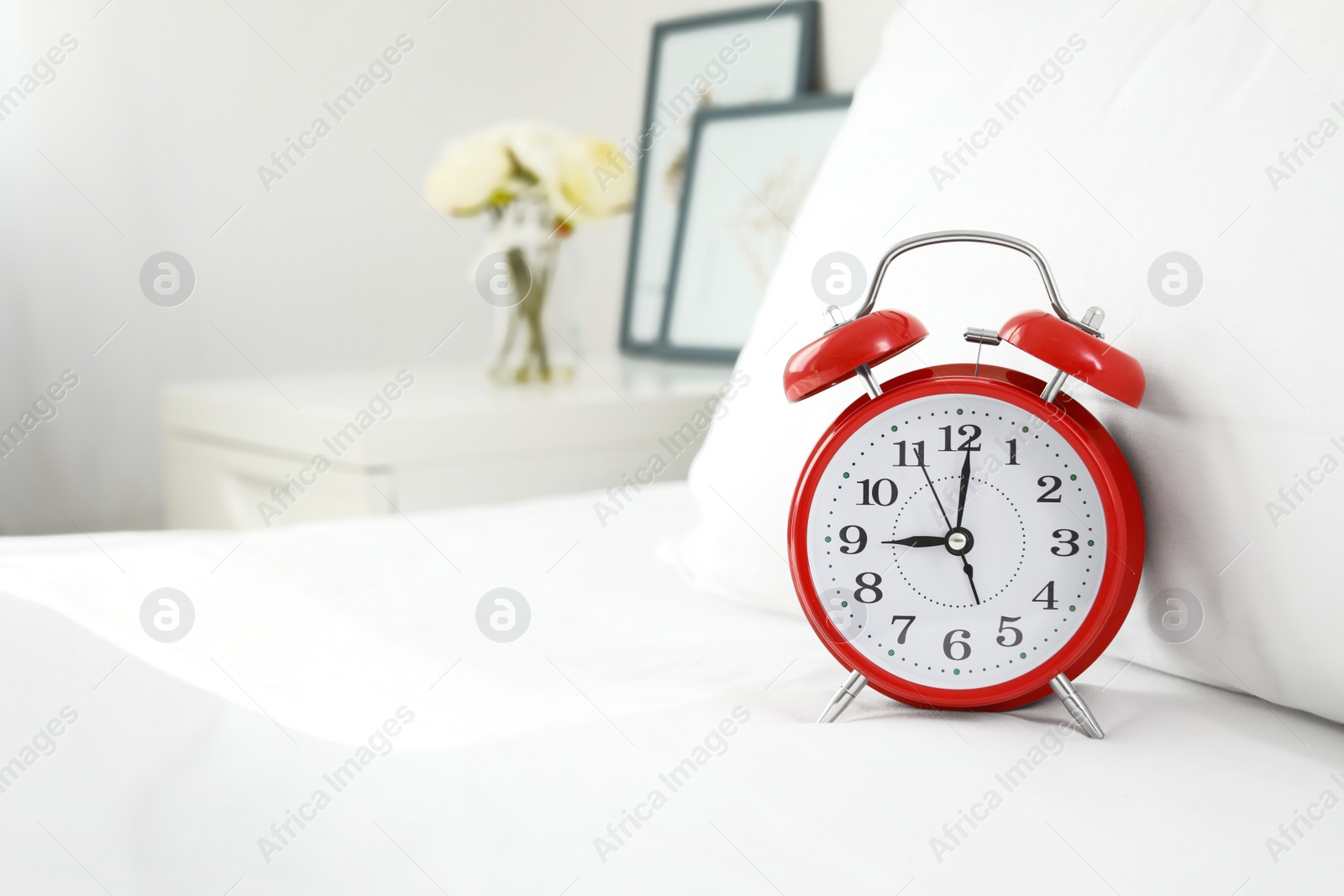 Photo of Alarm clock on bed. Time to wake up