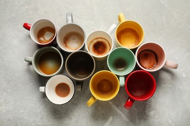 Photo of Many dirty cups after different coffee drinks on light grey marble table, flat lay