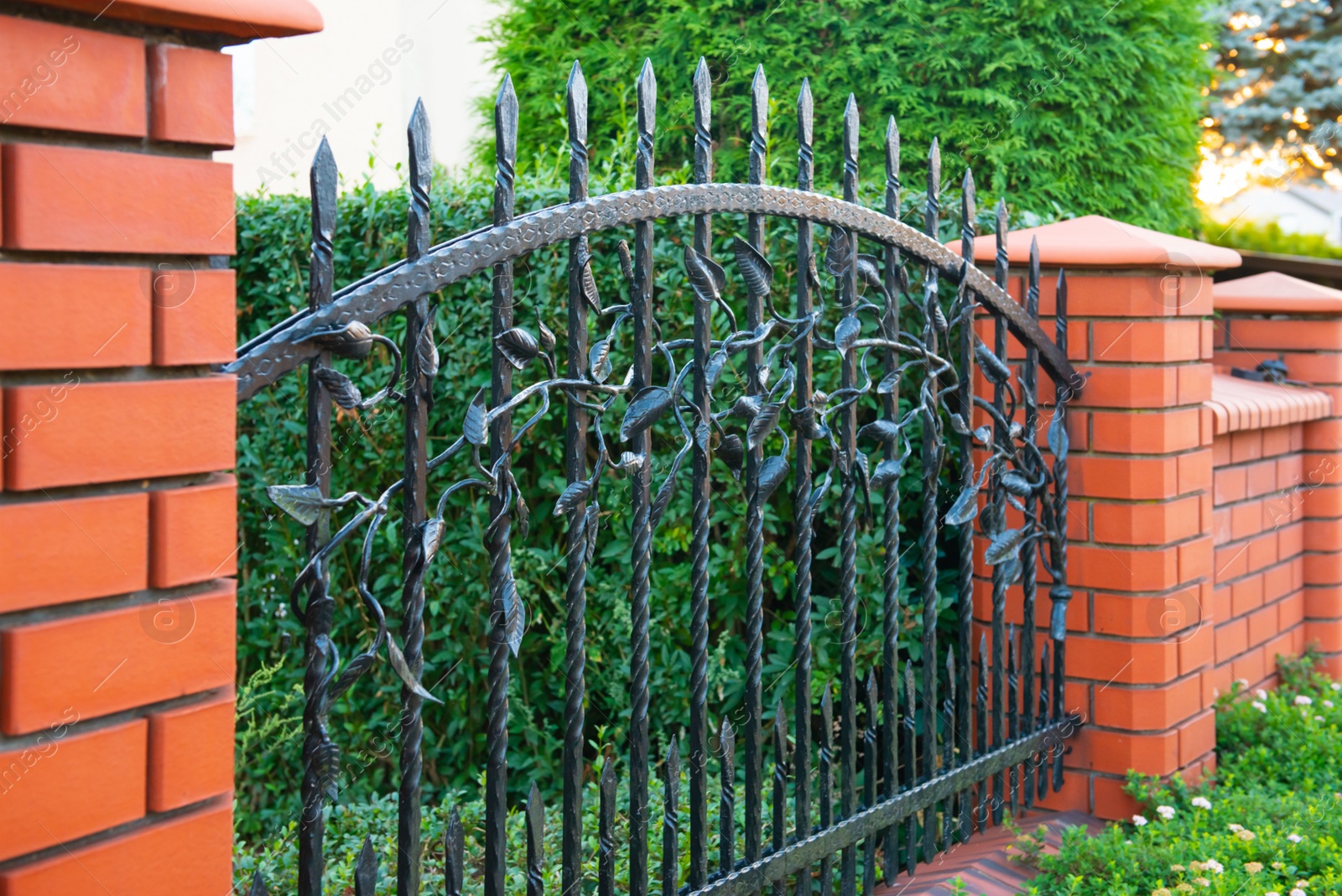 Photo of Beautiful brick fence with iron railing outdoors