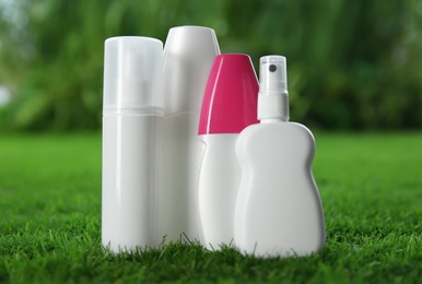 Photo of Many different insect repellents on green grass